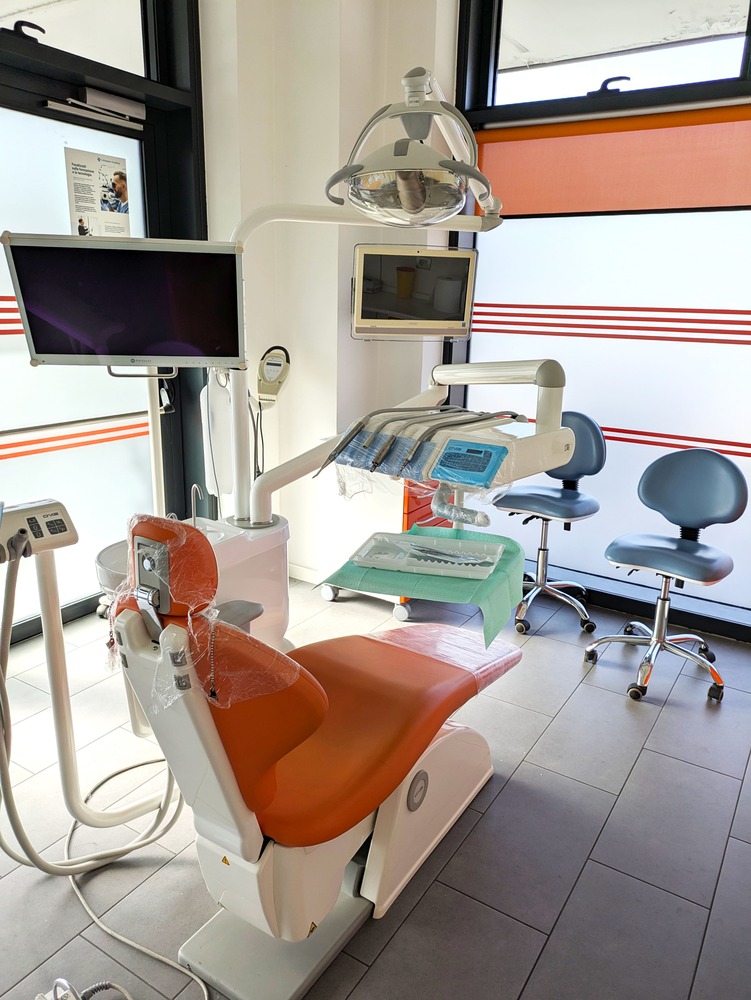poltrona dentista arancione e strumenti